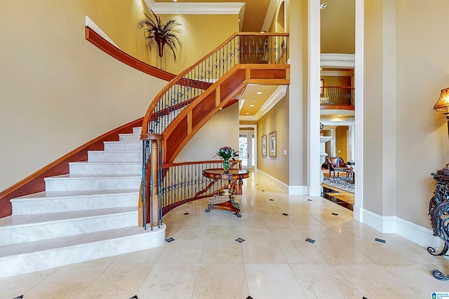 staircase with a towering ceiling, crown molding, and tile flooring