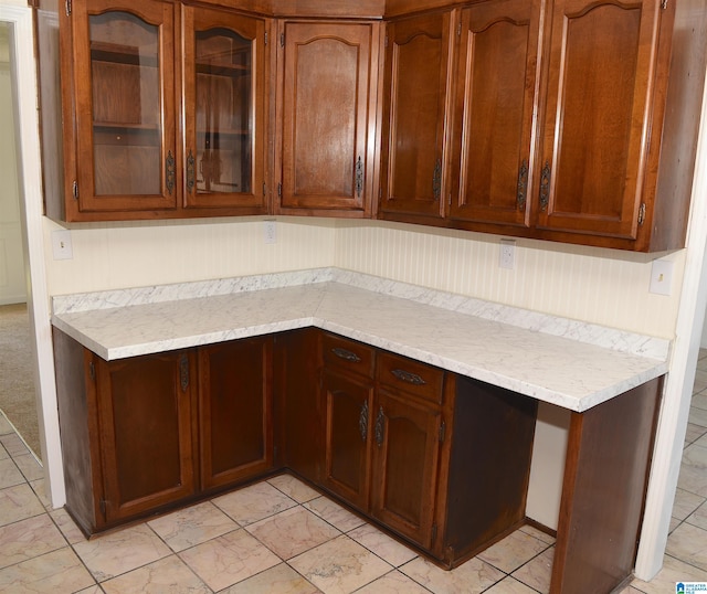 kitchen featuring light tile flooring and light stone countertops