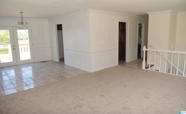 tiled spare room with ornamental molding, a notable chandelier, and french doors