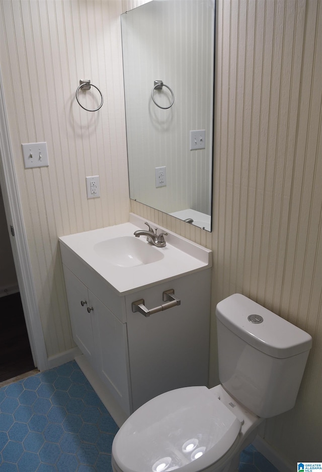 bathroom with toilet, tile floors, and vanity