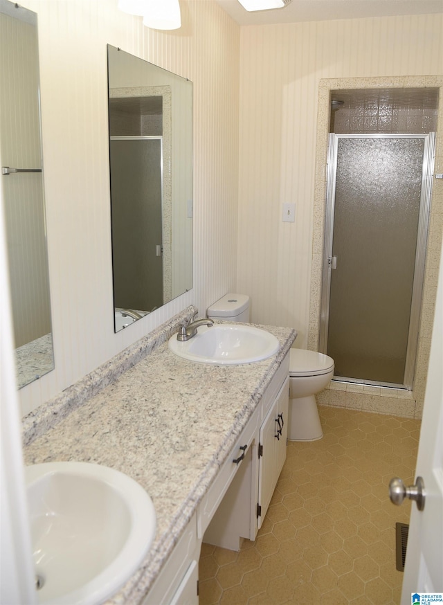 bathroom with oversized vanity, tile flooring, toilet, double sink, and walk in shower