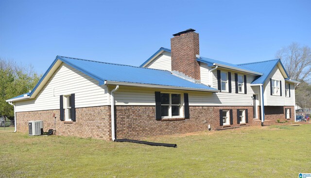 view of side of home featuring a lawn and central air condition unit