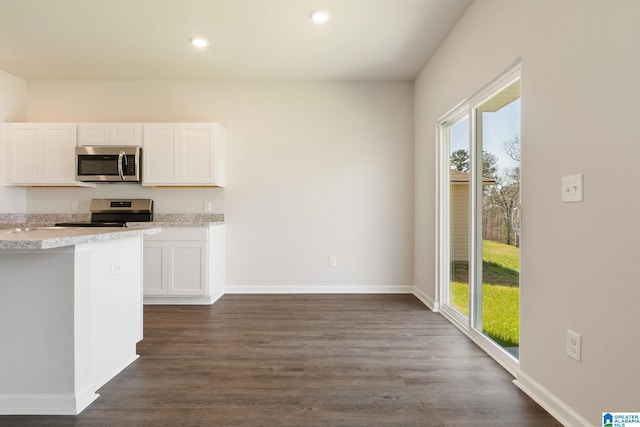 kitchen with dark hardwood / wood-style flooring, white cabinetry, and appliances with stainless steel finishes