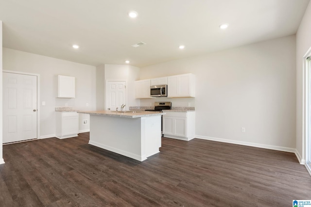 kitchen featuring stainless steel appliances, sink, white cabinets, an island with sink, and dark hardwood / wood-style floors