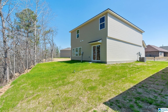 back of house featuring central AC unit and a yard