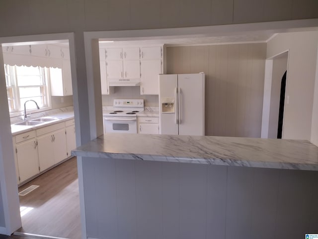 kitchen featuring white appliances, white cabinetry, light hardwood / wood-style floors, and sink