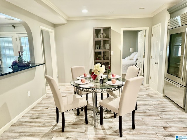 dining area featuring crown molding and light wood-type flooring