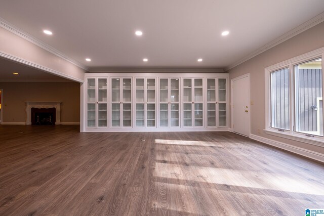 unfurnished living room with ornamental molding and light wood-type flooring