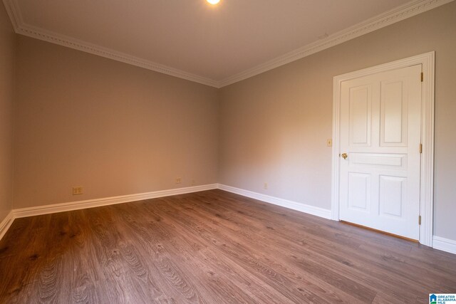 empty room with crown molding and dark wood-type flooring