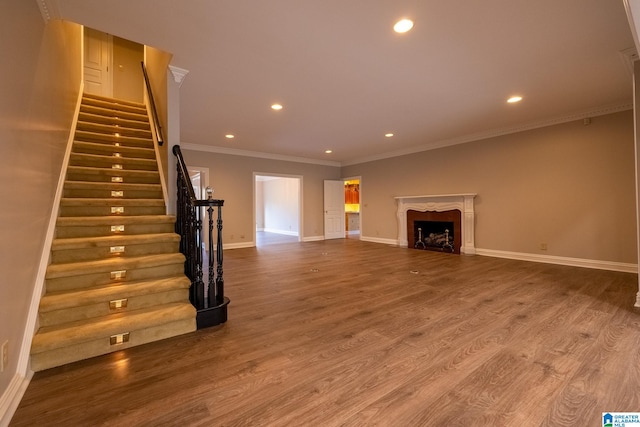 unfurnished living room featuring hardwood / wood-style floors and ornamental molding