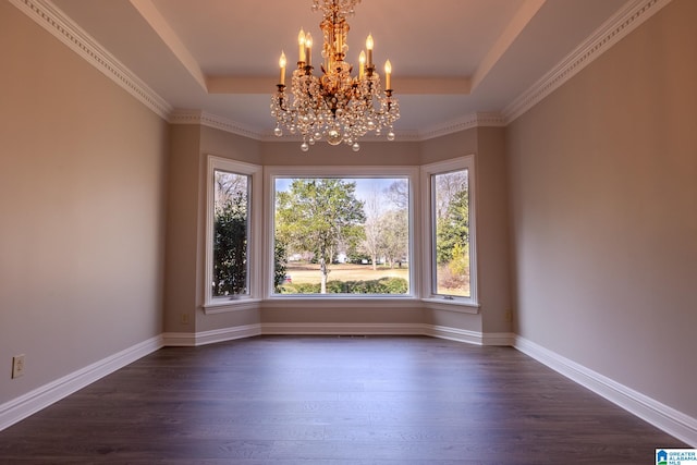 empty room with an inviting chandelier, dark hardwood / wood-style floors, a tray ceiling, and a healthy amount of sunlight