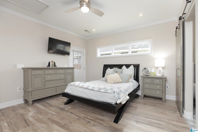 bedroom with a barn door, ornamental molding, ceiling fan, and light wood-type flooring