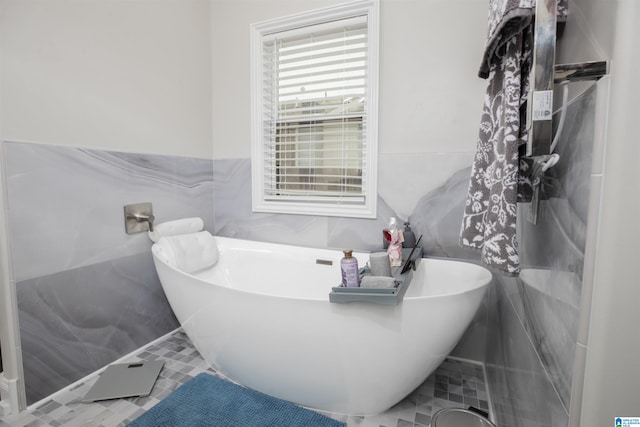 bathroom featuring tile flooring, tile walls, and a washtub