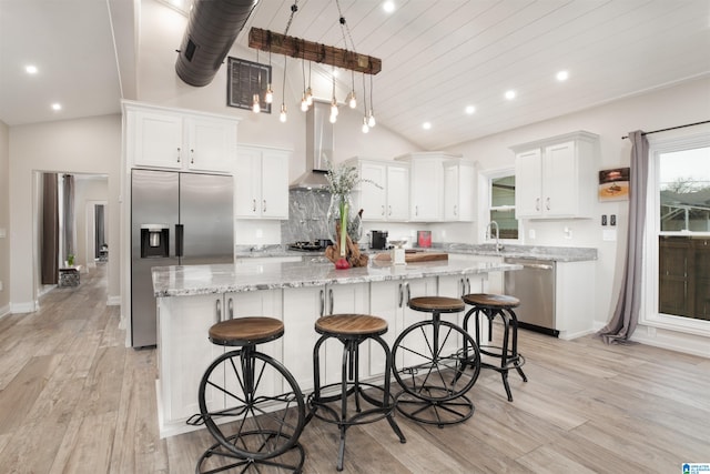 kitchen featuring white cabinetry, hanging light fixtures, appliances with stainless steel finishes, and light hardwood / wood-style flooring