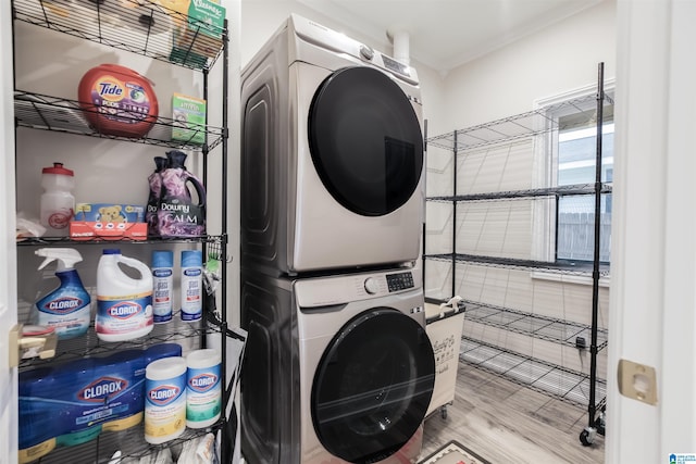 clothes washing area with stacked washing maching and dryer and light hardwood / wood-style floors