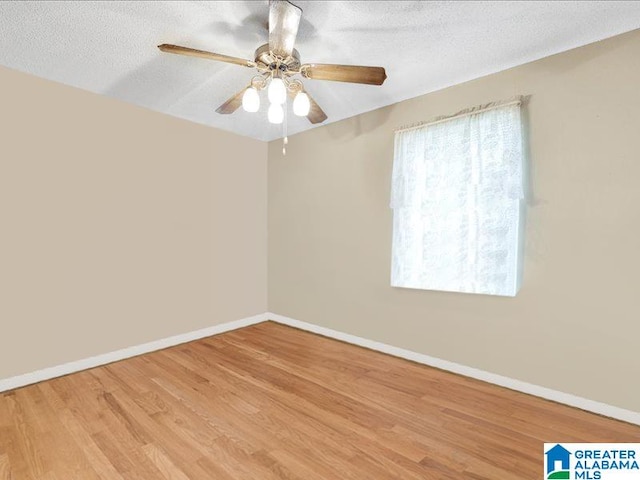 spare room featuring a textured ceiling, ceiling fan, and light wood-type flooring