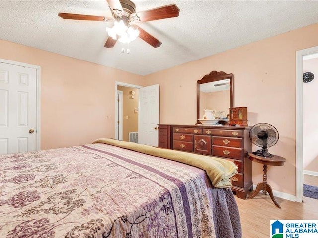 bedroom featuring a textured ceiling, ceiling fan, and light wood-type flooring