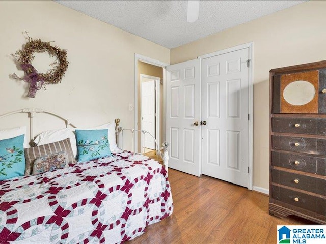 bedroom featuring ceiling fan, a textured ceiling, and dark hardwood / wood-style floors