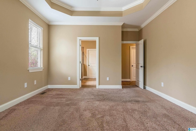 unfurnished bedroom featuring dark carpet, a raised ceiling, and ornamental molding