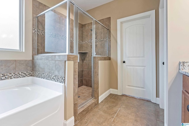 bathroom with tile floors, independent shower and bath, and vanity