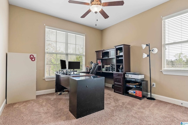 home office featuring light carpet and ceiling fan