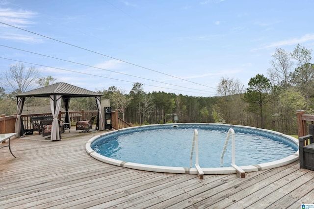 view of swimming pool featuring a wooden deck and a gazebo