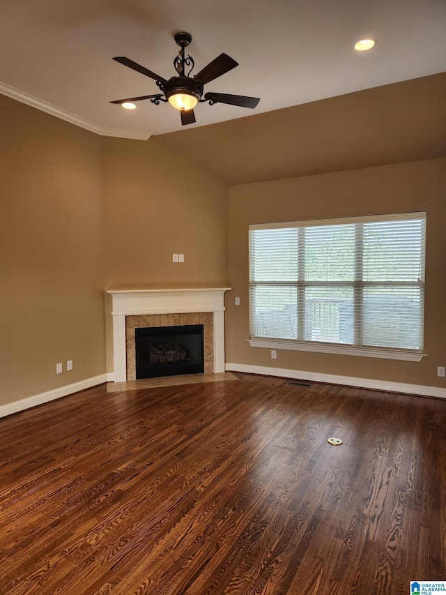 unfurnished living room featuring a tile fireplace, dark hardwood / wood-style floors, ceiling fan, and crown molding