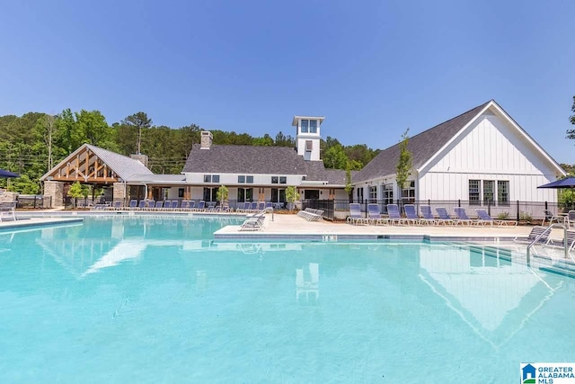 pool with a patio area and fence