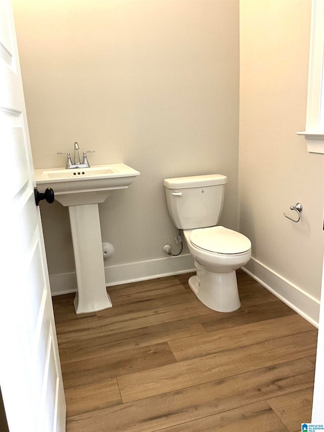 bathroom featuring wood finished floors, toilet, and baseboards