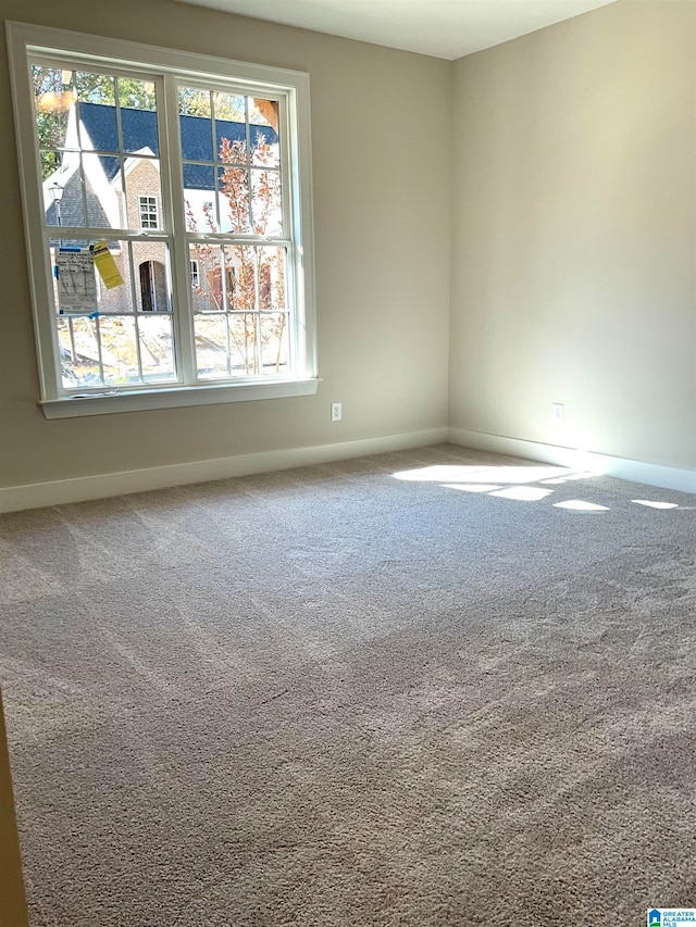 unfurnished room with carpet floors and baseboards