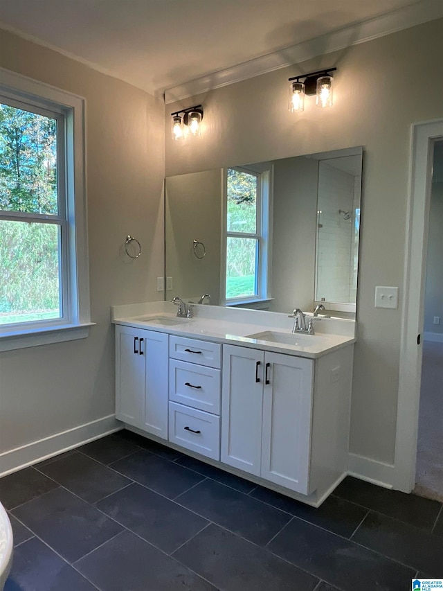 full bathroom featuring double vanity, tile patterned flooring, a sink, and baseboards