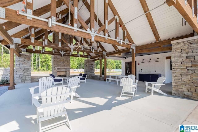 view of patio / terrace with a ceiling fan, an outdoor stone fireplace, and a gazebo