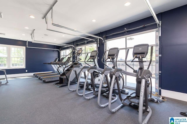 gym with a garage, baseboards, and recessed lighting