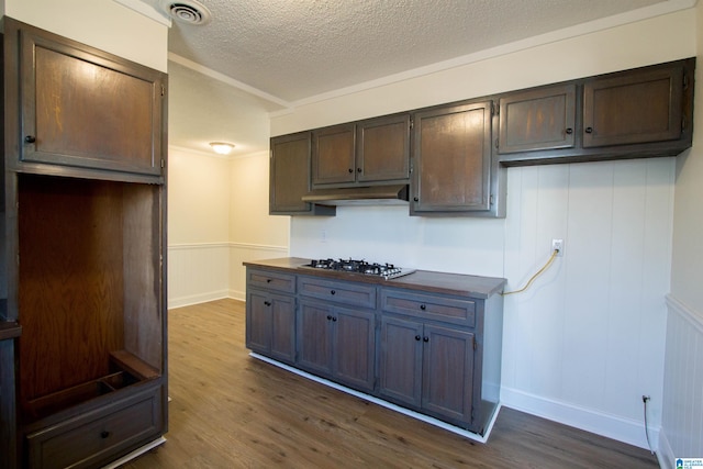 kitchen with dark hardwood / wood-style flooring, a textured ceiling, gas stovetop, and dark brown cabinets