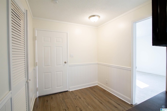 unfurnished room featuring dark carpet, a textured ceiling, and crown molding