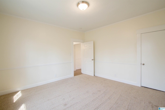 unfurnished room featuring crown molding and light colored carpet