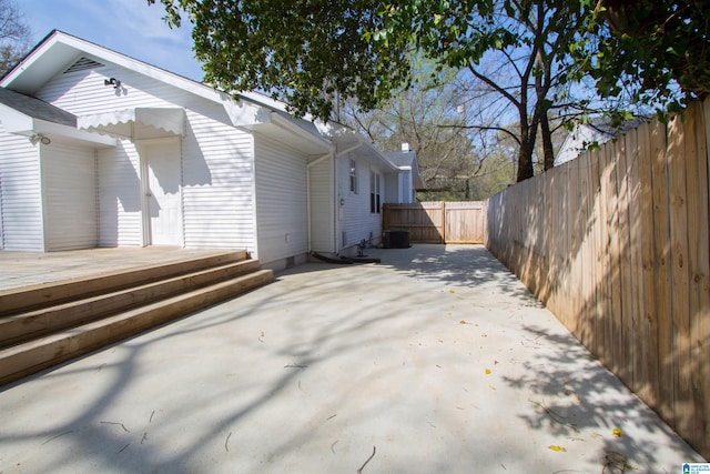 view of property exterior featuring a wooden deck and a patio