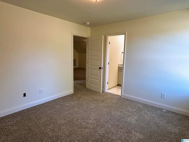 empty room featuring baseboards and light carpet