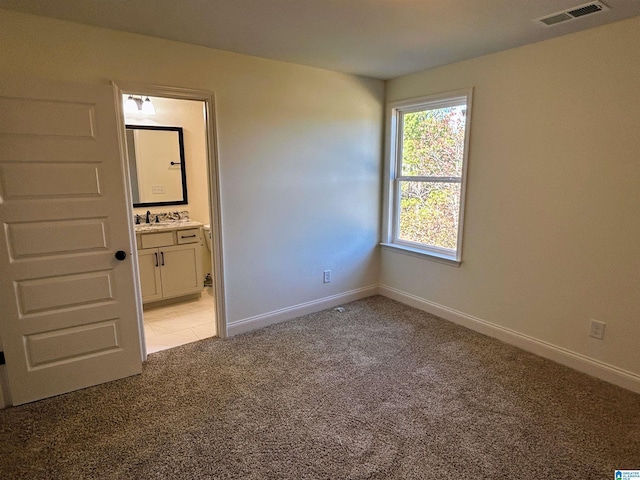 unfurnished bedroom featuring visible vents, baseboards, and light colored carpet