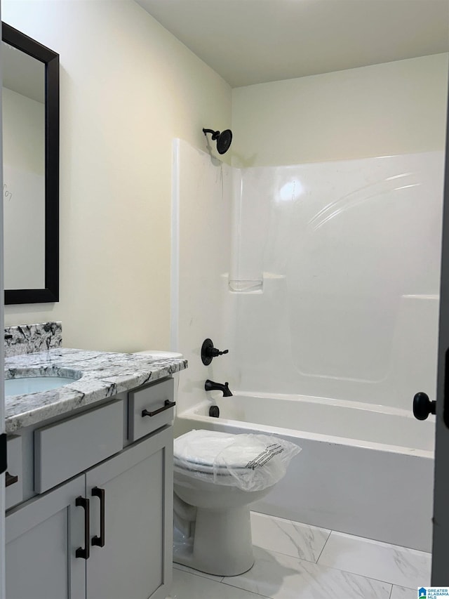 bathroom featuring vanity, toilet, tub / shower combination, and marble finish floor