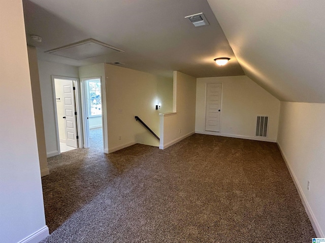 additional living space featuring visible vents, lofted ceiling, and carpet