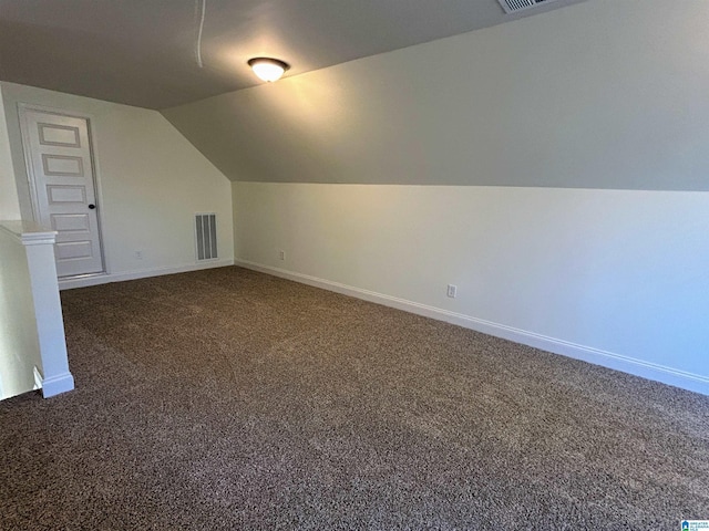 bonus room with dark colored carpet, visible vents, baseboards, and vaulted ceiling