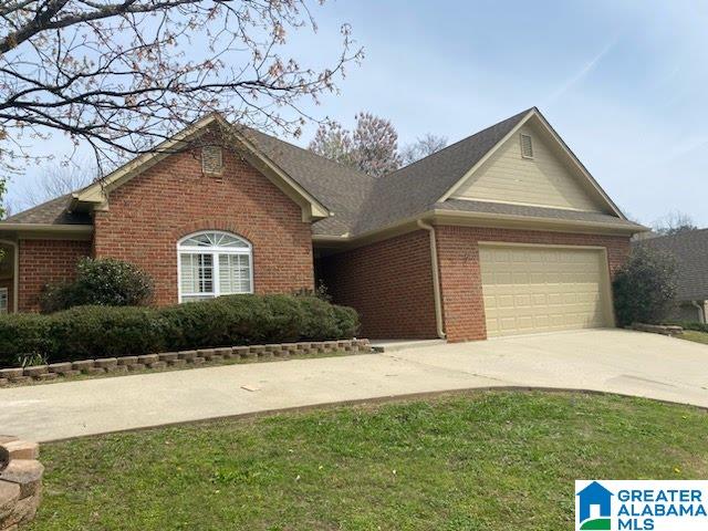 ranch-style home with a garage and a front yard