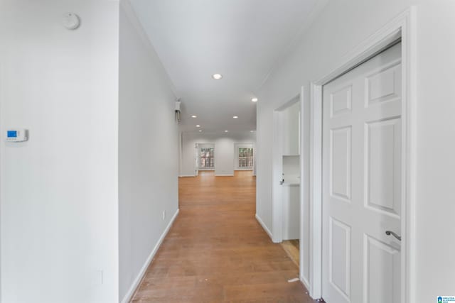 hall featuring crown molding and light hardwood / wood-style floors