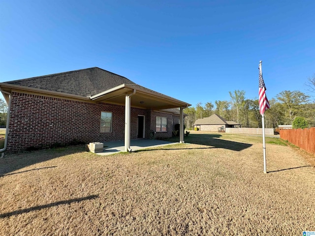 rear view of house with a patio and a lawn