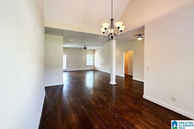 spare room with ceiling fan with notable chandelier and dark hardwood / wood-style floors