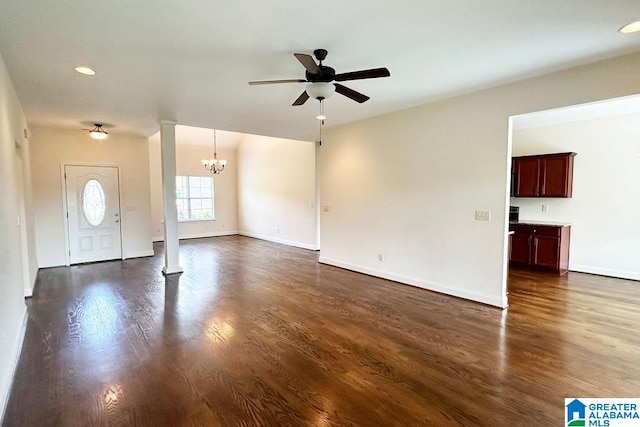 empty room with ceiling fan with notable chandelier and dark hardwood / wood-style floors