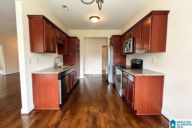 kitchen with sink, light stone countertops, stainless steel appliances, and dark wood-type flooring