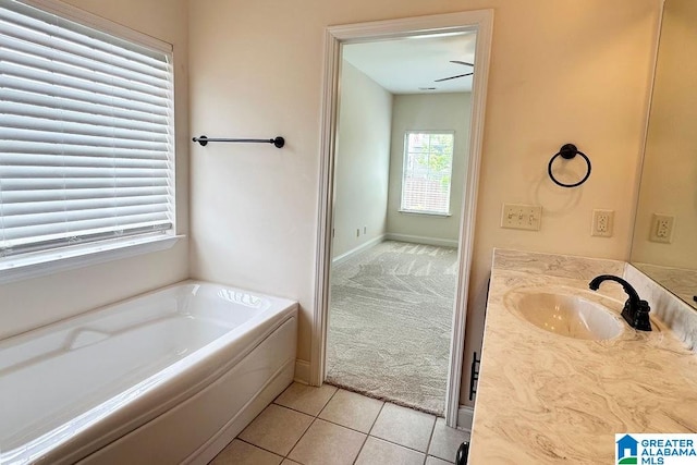 bathroom featuring tile flooring, a bathing tub, ceiling fan, and vanity