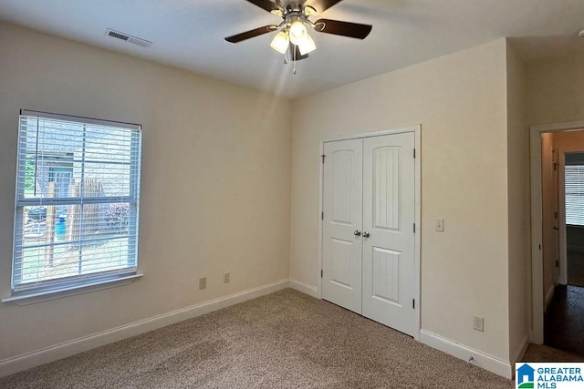 unfurnished bedroom featuring carpet flooring, a closet, and ceiling fan